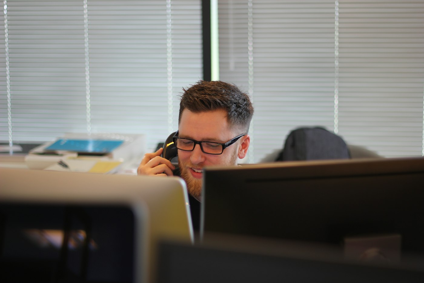Booking desk staff member answering a customer call on an office phone