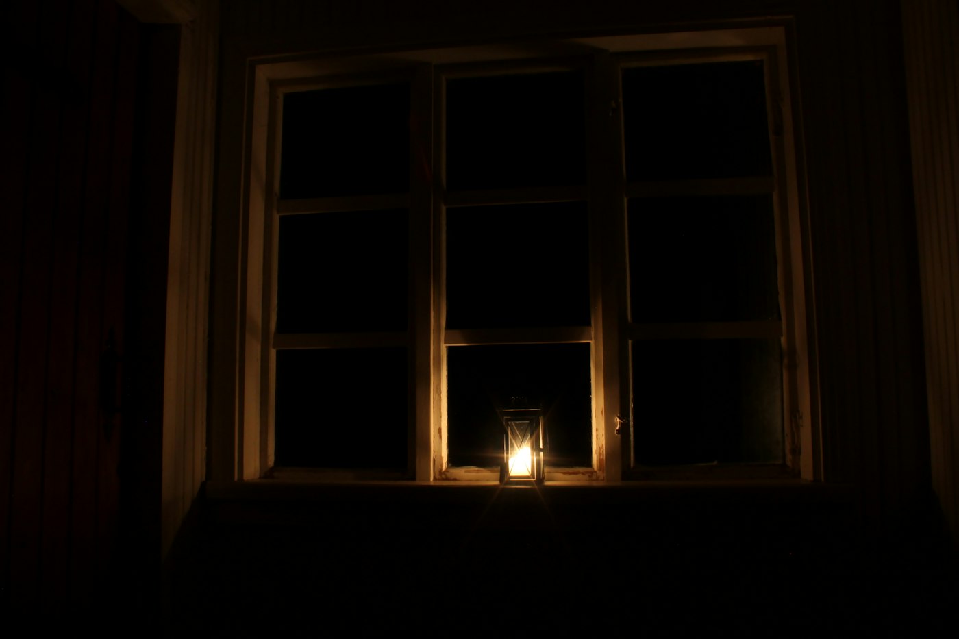 Single candle lighting a dark room during a power cut