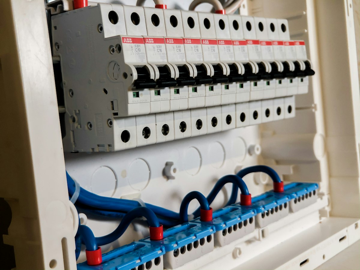 Row of white miniature circuit breakers mounted in a modern distribution board