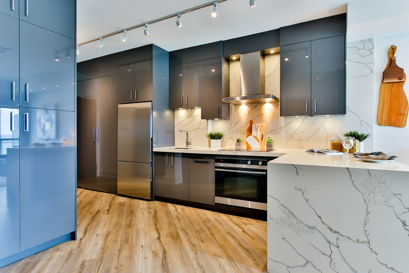 Modern apartment kitchen in Dhaka with grey cabinets, marble counters and under-cabinet lighting